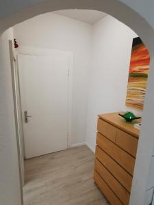 科隆Ferdimesse Apartments的一间设有白色门和木制梳妆台的房间