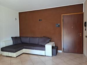 罗维戈Appartamento Roverella的坐在门旁的房间里的一个沙发