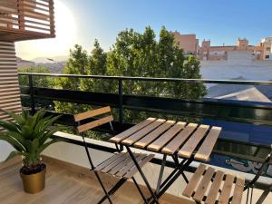 格拉纳达Aixa Granada的木凳坐在种植了植物的阳台