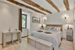 蒙蒂尼亚克Ferme des Petites Oreilles 4 étoiles的白色的卧室设有一张大床和一个窗户