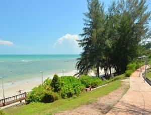 Kampong Tanah MerahD'Mentari Ocean View Resort Studio的享有树木繁茂的海滩和大海的景致。