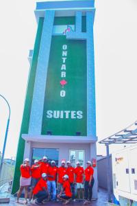 拉各斯ONTARIO SUITES的一群身穿红衬衫的人站在一座大楼前