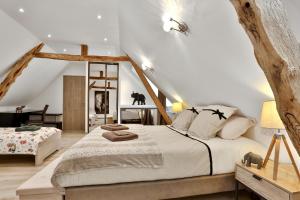 蒙蒂尼亚克Ferme des Petites Oreilles 4 étoiles的阁楼上的卧室配有一张大床