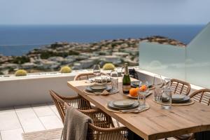 库姆布勒德尔索尔Infinity Horizon Apartment - Costa Blanca的阳台上配有带酒杯和橙子的木桌