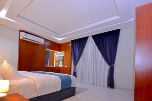 Al Mubarrazاجنحه كنزان的一间卧室配有一张带蓝色窗帘的大床