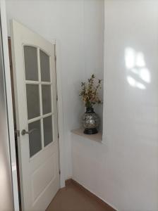 拜纳El Rincón de Paula的门旁的架子上有一个花瓶的房间