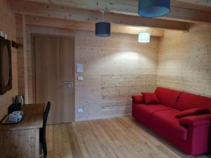 瓦托内切Chalet Gaspard的客厅设有红色的沙发和木墙