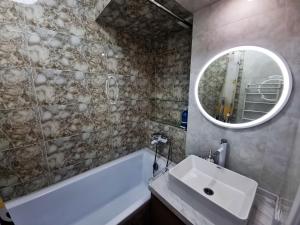 阿拉木图Очень уютная квартира рядом с посольством США的一间带水槽、浴缸和镜子的浴室