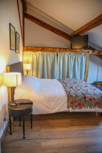 Tournan-en-BrieCROIX BLANCHE - LE LOGIS的一间卧室配有一张床和一张带台灯的桌子