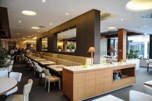 里米尼Oxygen Lifestyle Hotel的一间带桌椅的餐厅和一间酒吧