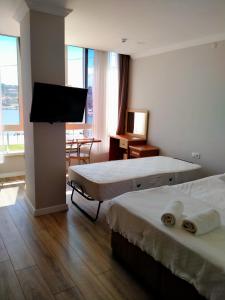 切什梅VENÜS PARK APART SUİTES的酒店客房设有两张床和一台平面电视。