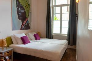 图卢兹库瓦巴拉农酒店的墙上画画的房间里设有两张床