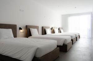 埃斯波森迪Marinhas Bed & Breakfast的房间里一排三张床