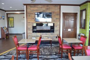 克拉尔维尔Quality Inn Coralville - Iowa River Landing的一间设有桌椅和电视的等候室