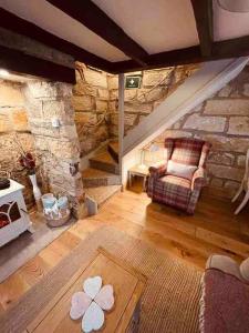 惠特比Cosy 400 yr old Cottage, Flowergate, Whitby的客厅配有椅子和石墙