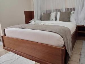 KakamegaLogmma Regency Hotel的卧室内的一张带木框的大床