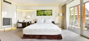 基加利基加利丽笙酒店和会议中心的卧室配有一张白色大床和一张书桌