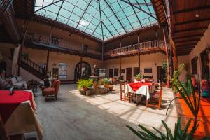 卡哈马卡Hotel Cajamarca的大房间设有桌椅和玻璃天花板
