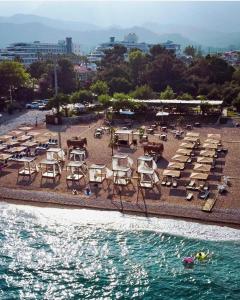 凯麦尔premium park apart otel的一组椅子和桌子,在海边的海滩上
