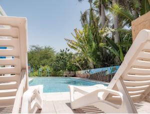 埃拉特Dive Time Villa的一个带两把草坪椅的游泳池和一个游泳池