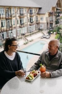 萨默兰萨默兰海滨度假酒店和Spa中心的坐在餐桌上吃一盘食物的男人和女人