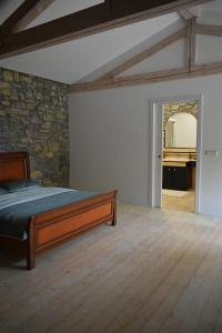 维帕瓦Small house in Vipava valley的一间卧室设有一张床和石墙
