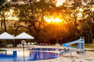阿拉沙Hotel Nacional Inn Araxá Previdência的度假村内带水滑梯的游泳池