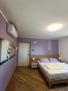 杰莫纳德尔夫留利B&B Rio Rai的一间卧室配有一张床和紫色的墙壁