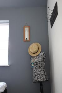 布洛克胡斯Motel Hune Apartments的挂在墙上的连衣裙上的草帽