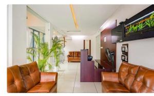 TripunnittaraManhas Townhose的客厅配有棕色皮革家具和植物