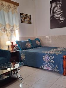 BandréléSTUDIOS BAMBO-EST Sunrise的一间卧室配有一张带蓝色床单和斑马图的床铺。