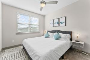 奥斯汀Modern & Chic 1BR Luxury Apts Close to Downtown & Airport的白色卧室配有一张带蓝色枕头的大床