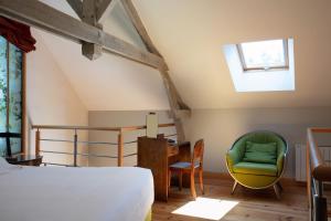 吉维尼Le Jardin des Plumes的卧室配有一张床和一张桌子及椅子