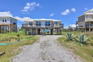 多芬岛Lovely Dauphin Island Cottage with Deck and Gulf Views的海滩上带土路的房子