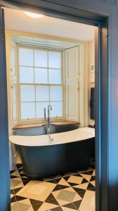 BowlingCustom House Hotel的带窗户的浴室设有大浴缸