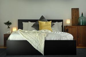 小谷村Cortina Apartment的卧室配有黑色和白色的床以及黄色枕头