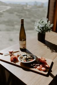 蒂梅丘拉Yurt Escape with Amazing Country Views的一瓶葡萄酒和一盘桌上的食物