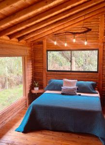 麦德林BRUMA BLANCA CHALETS的小木屋内一间卧室配有一张蓝色的床