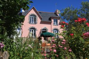 杜瓦讷内Chambre d'Hôte à Douarnenez的前面有鲜花的粉红色房子