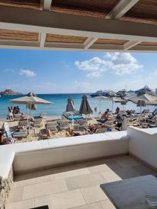 普拉迪斯亚罗斯Acrogiali Beachfront Hotel Mykonos的享有带椅子和遮阳伞的海滩美景