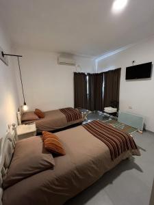 乌尼翁镇Casa Vergara I的一间卧室配有两张床和电视。