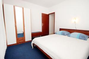 韦伯斯卡Apartments by the sea Mudri Dolac, Hvar - 5694的卧室配有带蓝色枕头的大型白色床