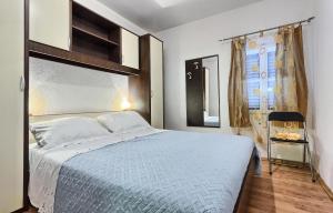 弗班吉Apartments by the sea Basina, Hvar - 5699的一间卧室配有一张床和一把椅子