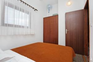 泰斯Apartment Nemira 5884c的一间卧室配有一张床和一个木制橱柜
