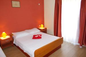 拉茨斯切Apartments by the sea Kneza, Korcula - 4342的一间卧室,配有一张红色帽子的床
