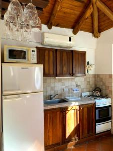 科隆TOLHUIN COLON的厨房配有白色冰箱和木制橱柜。