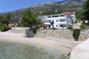 库希斯特Apartments by the sea Kuciste - Perna, Peljesac - 4545的石墙旁海滩上的房屋