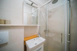 鲁巴达Apartment Lumbarda 4446b的带淋浴和盥洗盆的白色浴室