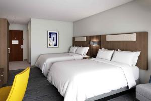 霍利斯特Holiday Inn Express & Suites - Hollister, an IHG Hotel的两张位于酒店客房的床,配有黄色椅子