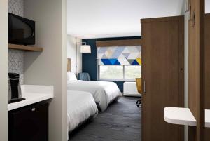 霍利斯特Holiday Inn Express & Suites - Hollister, an IHG Hotel的酒店客房设有两张床和窗户。